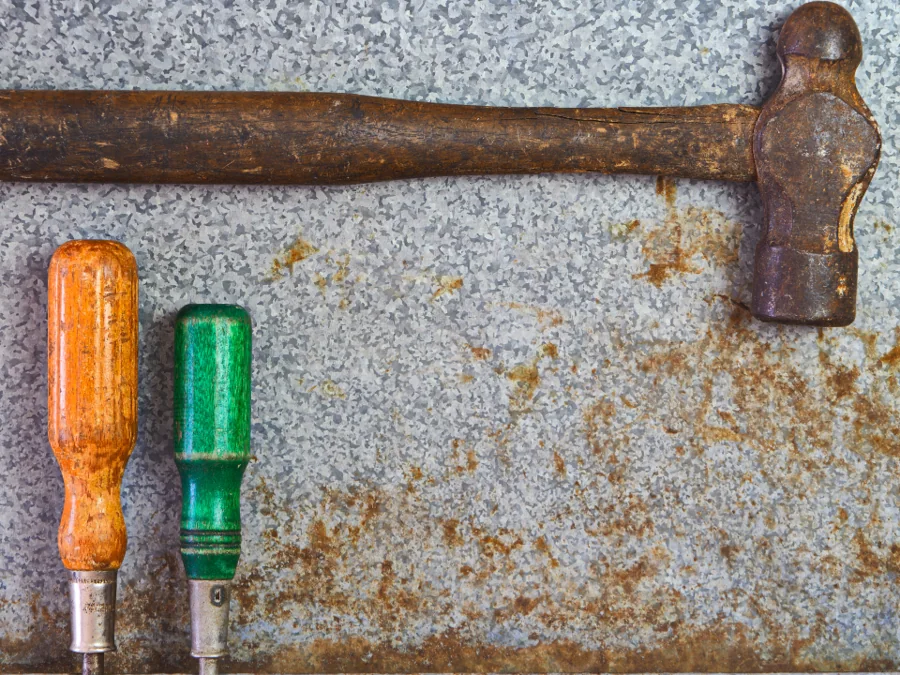 Hammer and screwdrivers on a galvanised metal sheet